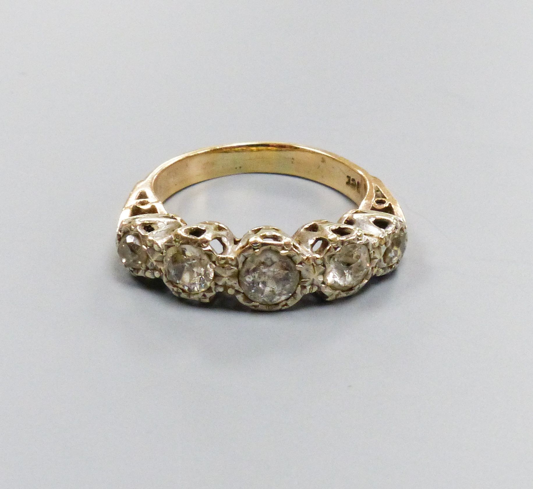 1887A five-stone diamond ring, 9ct white and yellow gold setting, claw-set with carved shoulders, size M, gross weight 4.3 grams.